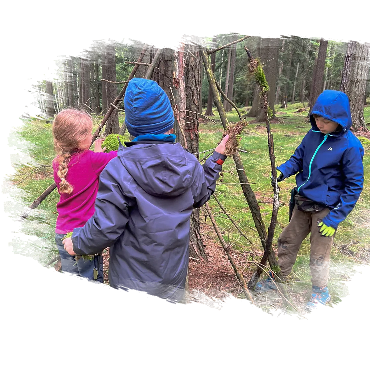 dzieci robią konstrukcję na ognisko w lesie